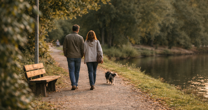 ein Paar geht mit dem Hund am See spazieren