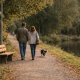 ein Paar geht mit dem Hund am See spazieren